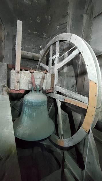 A bell and wheel of a wooden machine

AI-generated content may be incorrect.