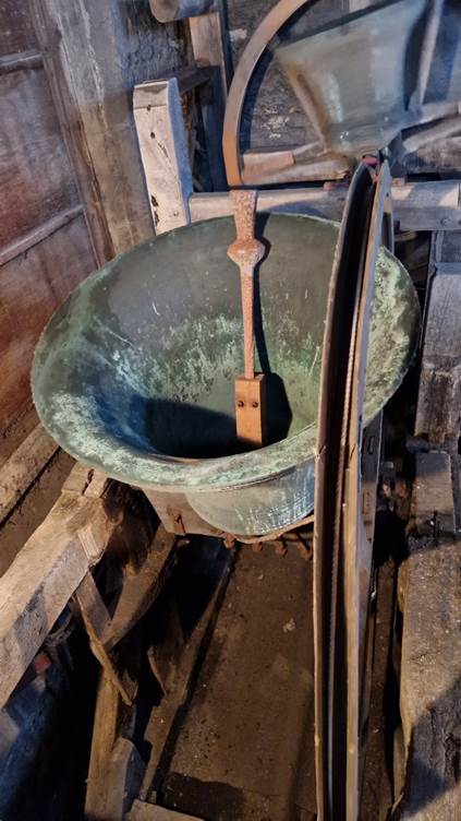 A large bell on a wooden stand

AI-generated content may be incorrect.